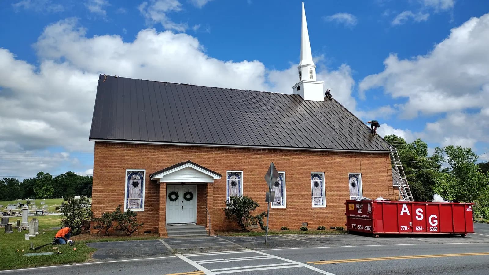 Historic brick church with a newly installed dark metal roof