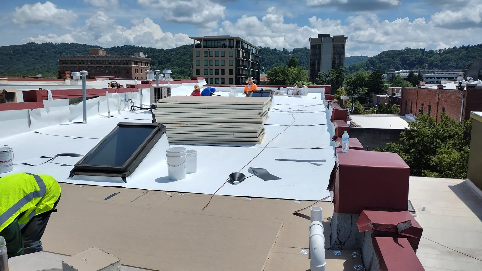 Commercial low-slope roof with white membrane being installed