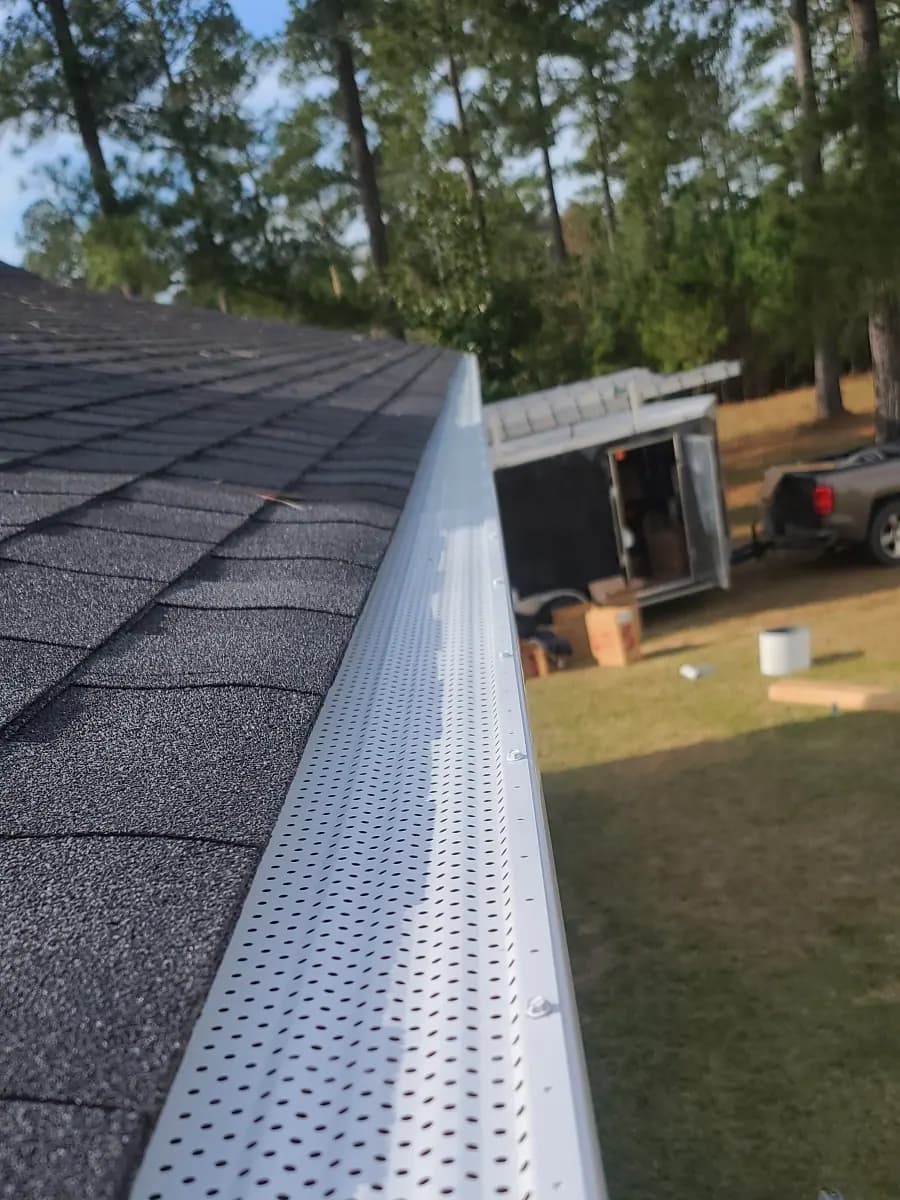 Seamless gutter with micro-mesh gutter guard installed along a roof edge