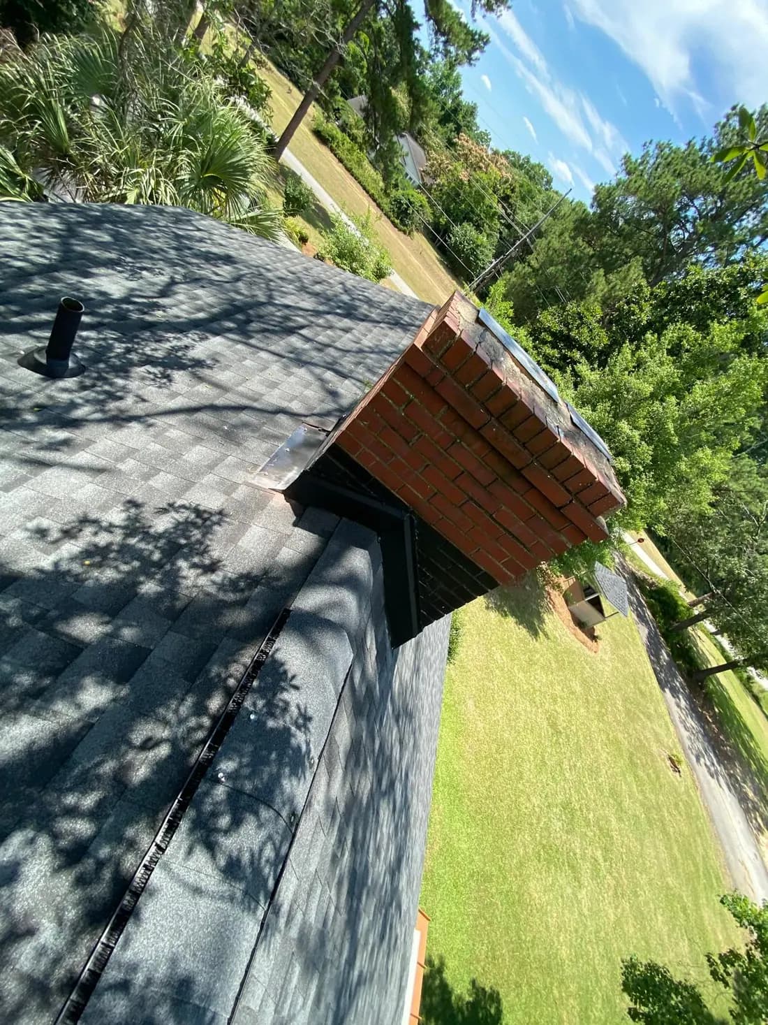 Roofer working on a steep-pitch shingle roof during an inspection